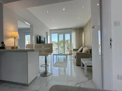 a kitchen and living room with a couch and a table at Lumière Retreat 2 in Larnaka