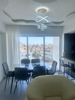a living room with a table and chairs and a large window at Near Finikoudes beach 1 in Larnaka