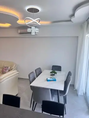 a dining room with a white table and chairs at Near Finikoudes beach 1 in Larnaka
