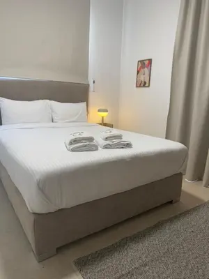 a bedroom with a large bed with white sheets at Kroisou Comfort Stay 2 BEDROOM in Ayios Dhometios