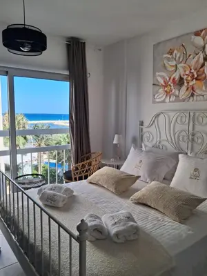 a bedroom with a bed with a view of the ocean at Lazuli Sea View & Pool Studio 303 in Larnaka