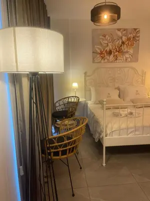 a bedroom with a bed and a table and a lamp at Lazuli Sea View & Pool Studio 303 in Larnaka