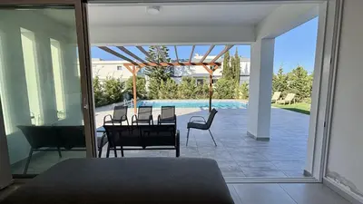 a patio with a table and chairs and a pool at Sunrise Villa with Pool by TrulyCyprus in Pervolia