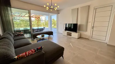 a living room with a couch and a tv at Sunrise Villa with Pool by TrulyCyprus in Pervolia