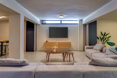 a living room with two couches and a tv at Pantio Living Villa in Ayia Napa