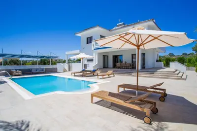 a villa with a swimming pool and an umbrella at Pantio Living Villa in Ayia Napa