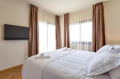 a bedroom with a white bed with two towels on it at Pantio Living Villa in Ayia Napa