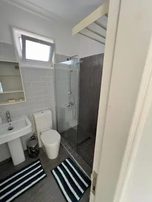 a bathroom with a shower and a toilet and a sink at Villa Large Garden&Outdoor Space in Lageia