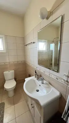 a bathroom with a sink and a toilet and a mirror at Villa Porta Aurea in Ayia Napa