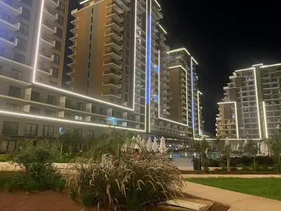 a group of tall buildings at night at Riverside Life Residence in İskele