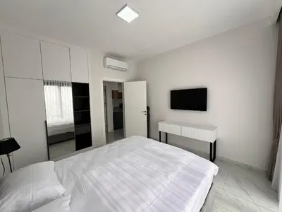 a white bedroom with a bed and a desk at Riverside Life Residence in İskele