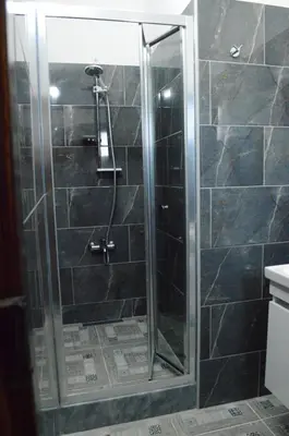 a shower with a glass door in a bathroom at Ecolive Guest House in Ayios Epiphanios