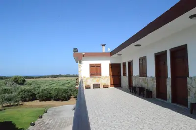 a house with a balcony with a view of a field at Ecolive Guest House in Ayios Epiphanios
