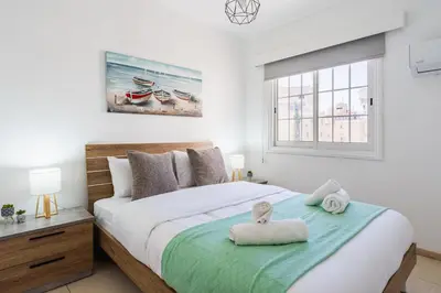 a bedroom with a bed with two towels on it at Destiny 1-Bedroom Apartment in Larnaka