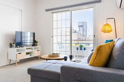 a living room with a couch and a large window at Destiny 1-Bedroom Apartment in Larnaka