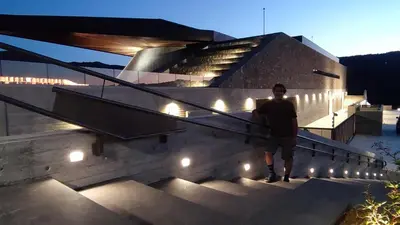 a man standing on some stairs with lights at Ambeli - Ambeloui in Kalopanayiotis