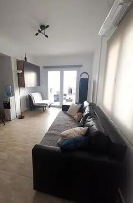 a person laying on a couch in a living room at Kennedy 5 apartman Ayia Napa in Ayia Napa