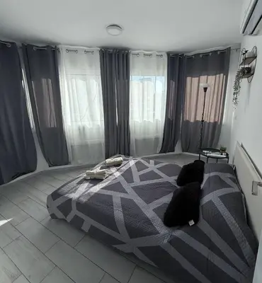 a bedroom with a bed in a room with windows at Kypa rooms 50 steps to the beach in Larnaka
