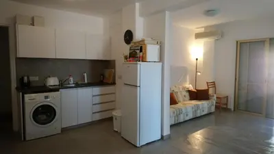 a kitchen with a refrigerator and a couch in a room at Apartment Sun Kapparis in Paralimni