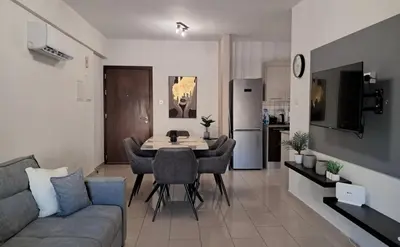a living room with a couch and a dining room table at Lama's Residence in Nicosia