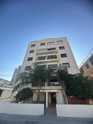 a tall building with a palm tree in front of it at Lama's Residence in Nicosia