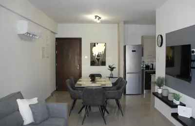 a living room with a table and chairs and a kitchen at Lama's Residence in Nicosia