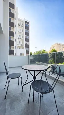 a table and two chairs sitting on a balcony at Poolside Lux Apartment in Larnaka