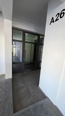 an entrance to an office building with glass doors at Poolside Lux Apartment in Larnaka