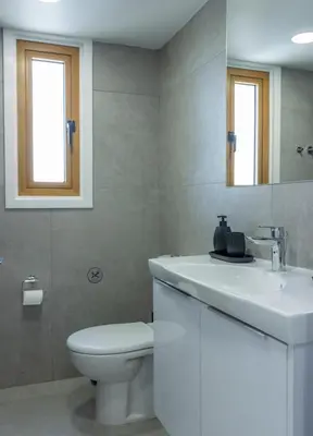a bathroom with a toilet and a sink and a mirror at Stylish Modern City Center Stay in Nicosia