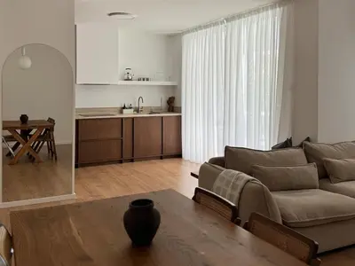 a living room with a couch and a table and a kitchen at Themelio Living 2-Bed Apartment Nicosia City Centre in Nicosia