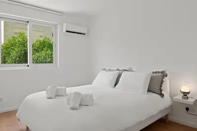 a white bed in a white room with a window at Themelio Living 2-Bed Apartment Nicosia City Centre in Nicosia