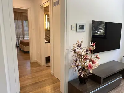 a living room with a vase of flowers on a table at Luxury Limassol Seaside Pool Suite in Limassol