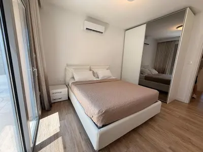 a small bedroom with a bed and a mirror at Luxury Limassol Seaside Pool Suite in Limassol