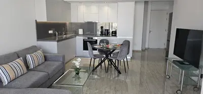 a living room with a couch and a table and a kitchen at AURA Apt Modern 1BR in Central Limassol and Free Parking in Limassol