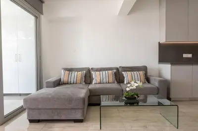 a living room with a couch and a glass table at AURA Apt Modern 1BR in Central Limassol and Free Parking in Limassol