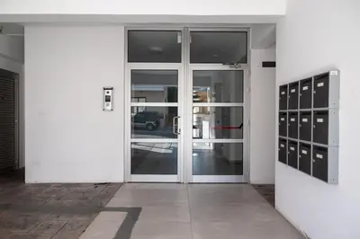 a white building with doors and windows and a street at AURA Apt Modern 1BR in Central Limassol and Free Parking in Limassol