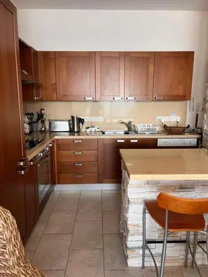 a kitchen with wooden cabinets and a counter top at Sandy Kisses in Larnaka