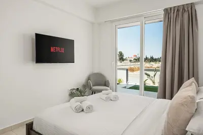 a bedroom with a bed with a tv and a window at Chic & Elegant Hideaway - Your Luxury Escape in Livadhia
