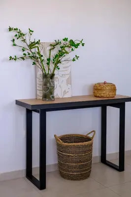 a black console table with a vase and a basket at Chic & Elegant Hideaway - Your Luxury Escape in Livadhia