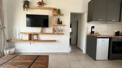 a kitchen with a flat screen tv on a wall at Teak Charm in Larnaka