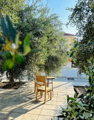 a wooden table and a chair sitting next to a table at Teak Charm in Larnaka