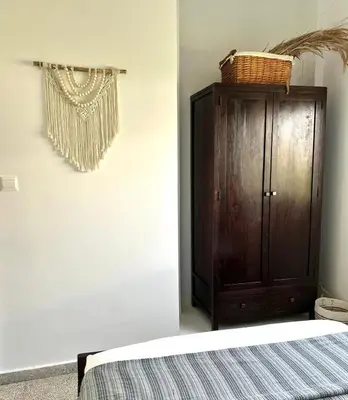 a bedroom with a bed and a wooden cabinet at Teak Charm in Larnaka