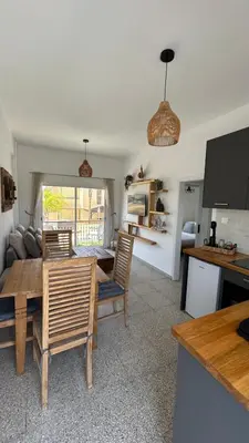 a living room with a wooden table and chairs at Teak Charm in Larnaka