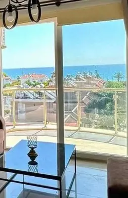 a living room with a glass table and a large window at Two Bedrooms LongBeach SeaView Escape in Paralimni