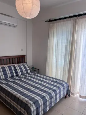 a bedroom with a bed with a blue and white checked blanket at Esentepe Turtle Bay Village - The Boho Breeze Holiday Home in Aglantzia