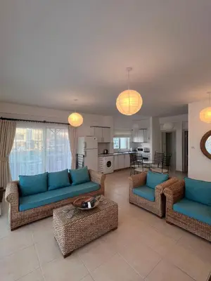 a living room with blue couches and a kitchen at Esentepe Turtle Bay Village - The Boho Breeze Holiday Home in Aglantzia