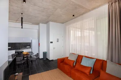 a living room with an orange couch and a table at Bridge House 202-2BR Modern Apartment in Limassol