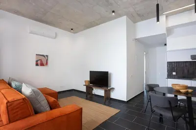 a living room with a couch and a tv and a table at Bridge House 202-2BR Modern Apartment in Limassol