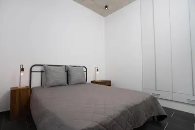 a bedroom with a bed with two night stands and two lamps at Bridge House 202-2BR Modern Apartment in Limassol
