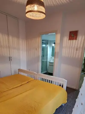 a bedroom with a yellow bed and a mirror at Larnaca Breeze in Pyla
